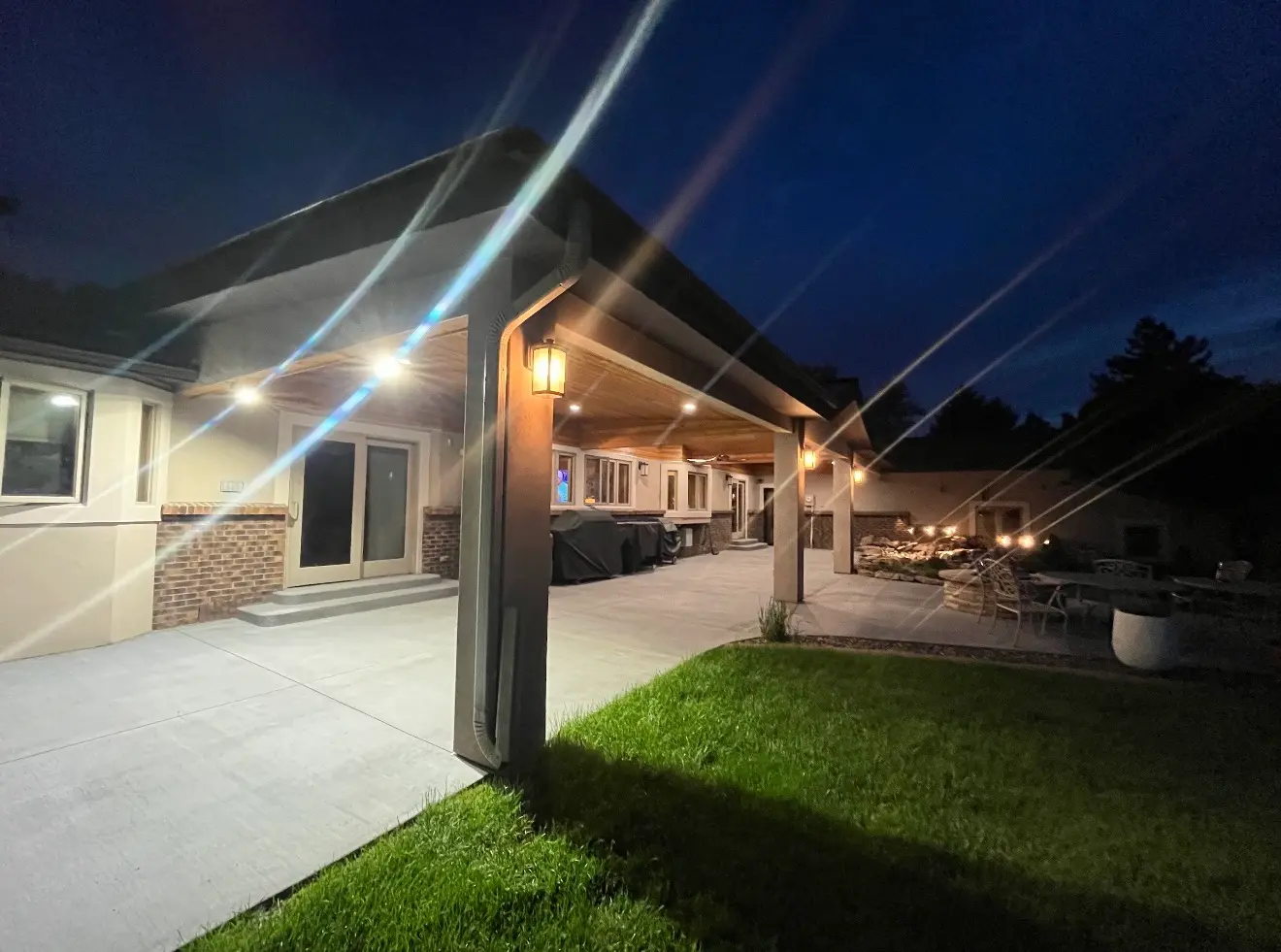 Angled night view of cascade patio roof cover and stucco pillars in Boulder Colorado