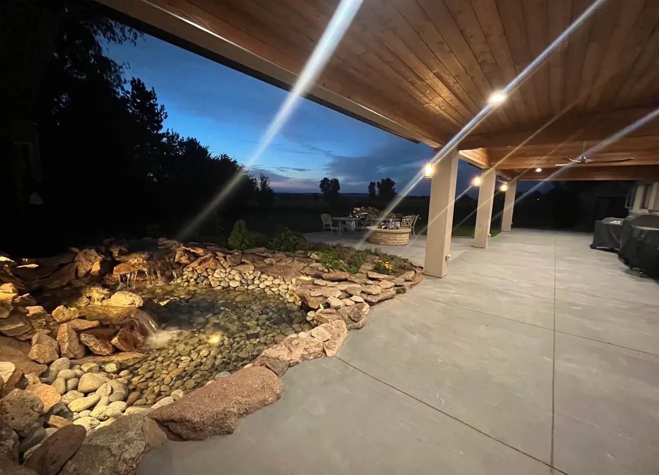 Covered patio next to water feature at dusk in Boulder Colorado