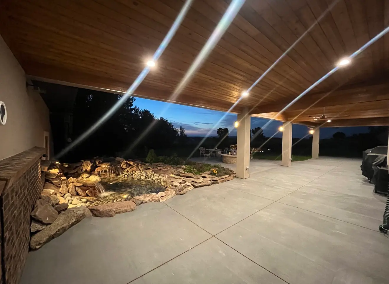 Wide dusk view of patio roof cover and water feature in Boulder Colorado