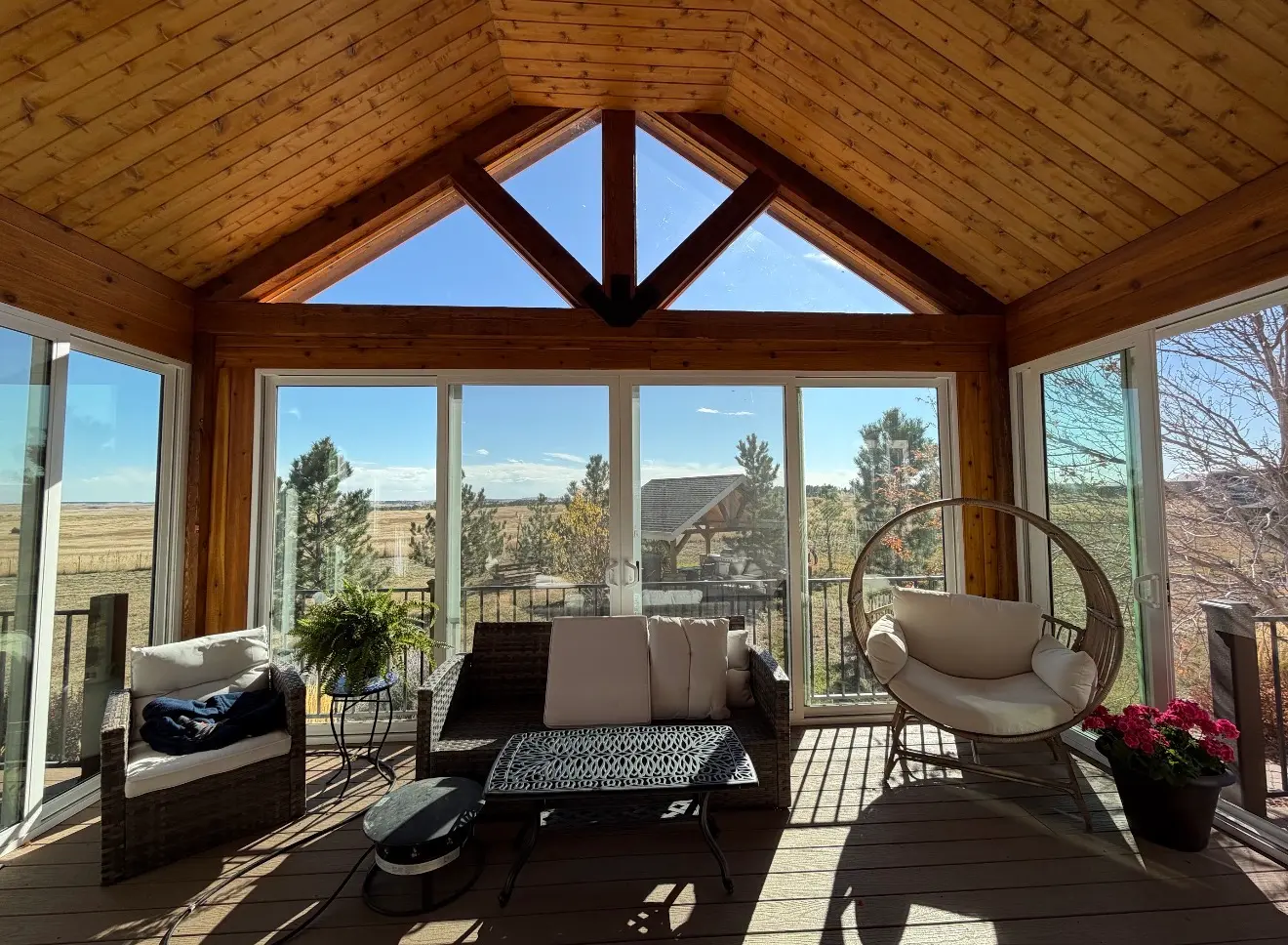 Interior view of elevated sunroom with cedar ceiling and panoramic glass in Elizabeth Colorado