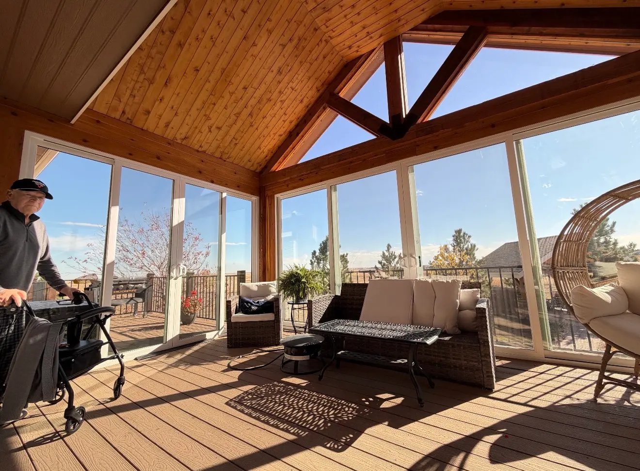 Interior view showing panoramic glass walls and deck access in elevated sunroom in Elizabeth Colorado
