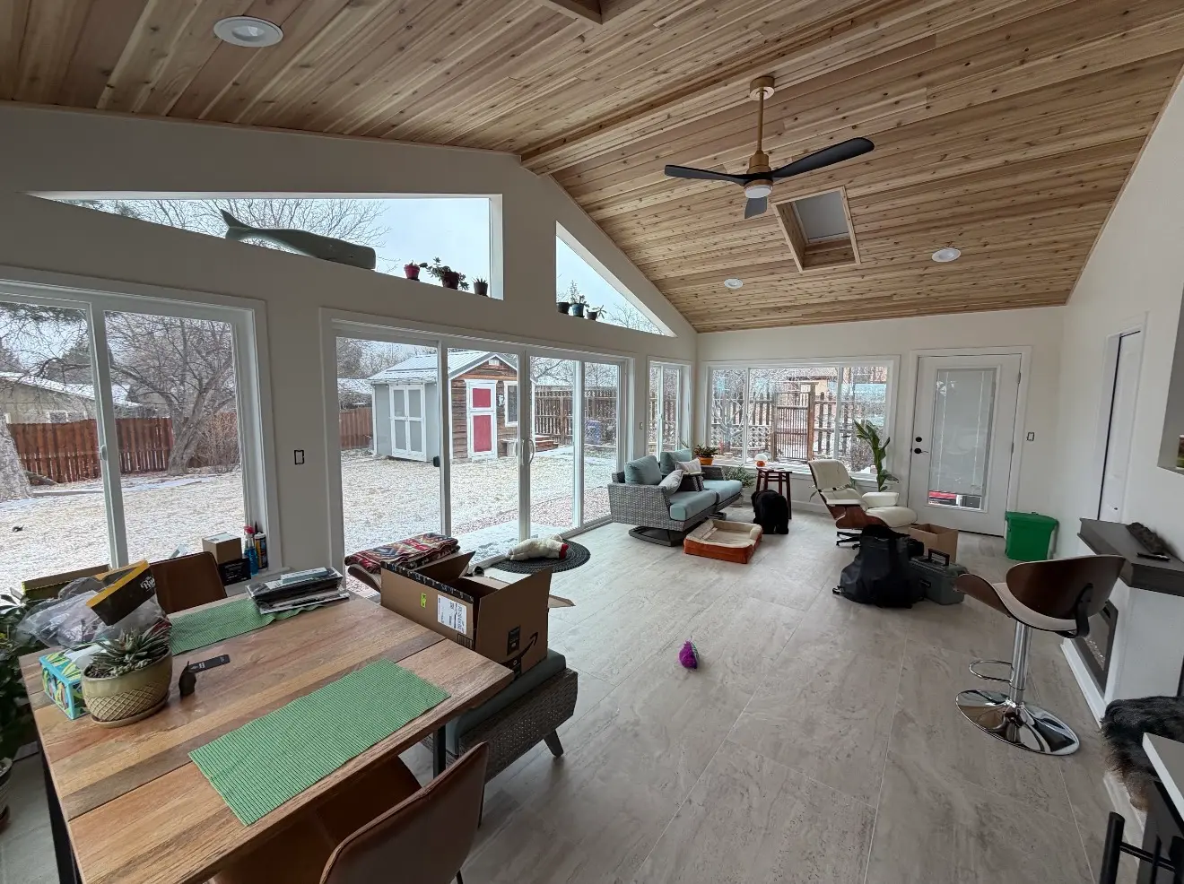 Interior of completed sunroom with large windows and vaulted wood ceiling in Boulder Colorado